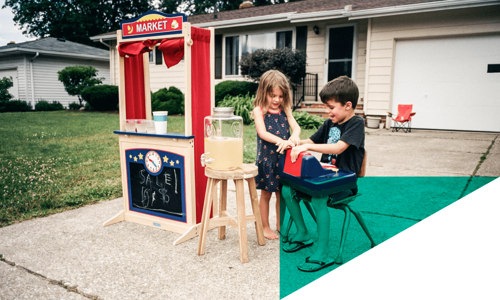 two children setting up a lemonade stand in driveway