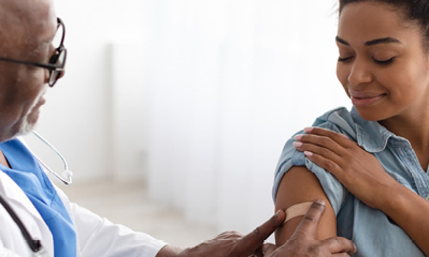 doctor putting bandaid on woman