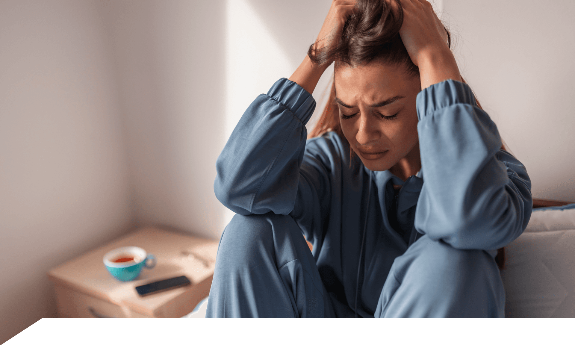A woman with her hands in her hair looking upset