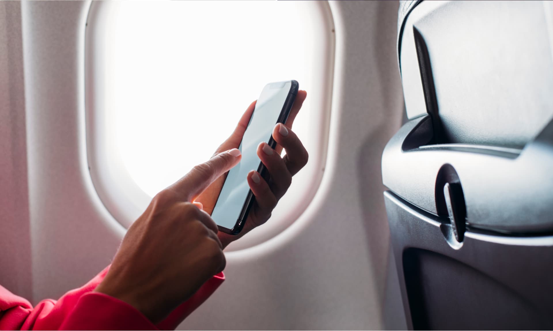 Close up shot of an unrecognisable woman's hand while holding a phone in an airplane